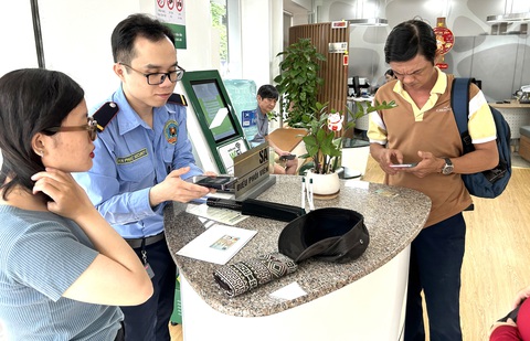 Một người đang gọi điện thoại cho ngân hàng để báo cáo về một giao dịch đáng ngờ